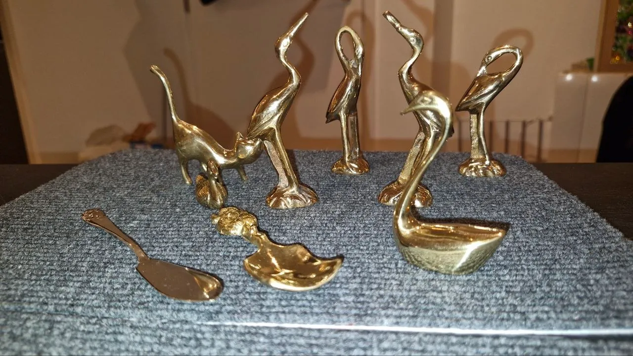 Brass crane, cat and swan figurines gleaming after cleaning and polishing